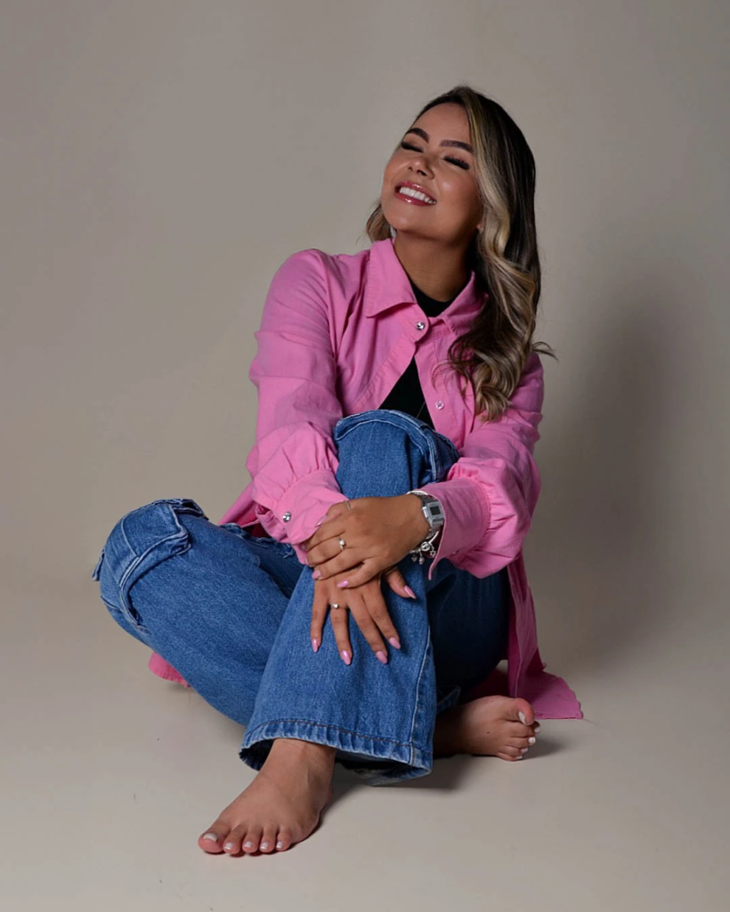 Bianca sentada no chão e sorrindo